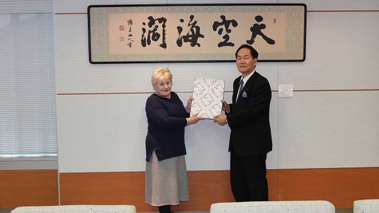 Angela receiving a gift from Governor Hamada